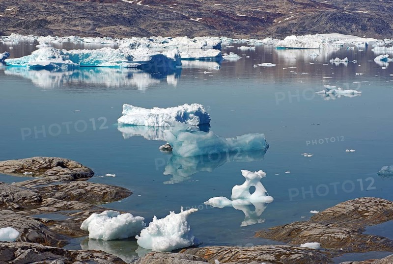 Ice floes are reflected in calm, clear water in an arctic landscape, Tiniteqilaaq, Tasilaq, Greenland, Denmark