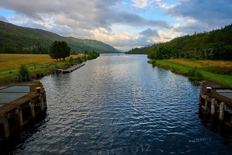 A river flows between wooded hills in a peaceful landscape under a cloudy sky, Caledonian Canal, Loch Ness, Scotland, United Kingdom, Great Britain