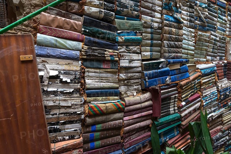 Stacked books on a wall after flood damage in a bookstore, Venice, Veneto, Italy