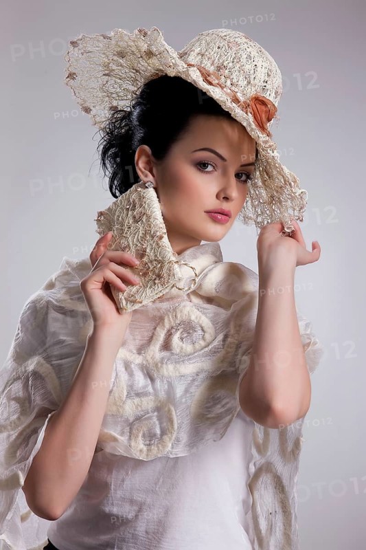 Young attractive woman dressed in fashionable handmade clothing on isolated background