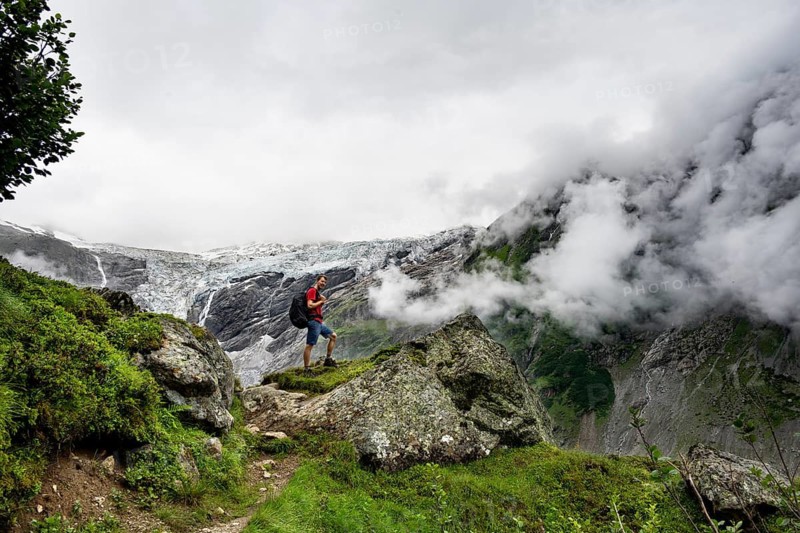Mountaineers on a hiking trail, cloudy mountain landscape with Grindelwald-Fiescherfirn glacier, Bernese Alps, Bernese Oberland, Switzerland