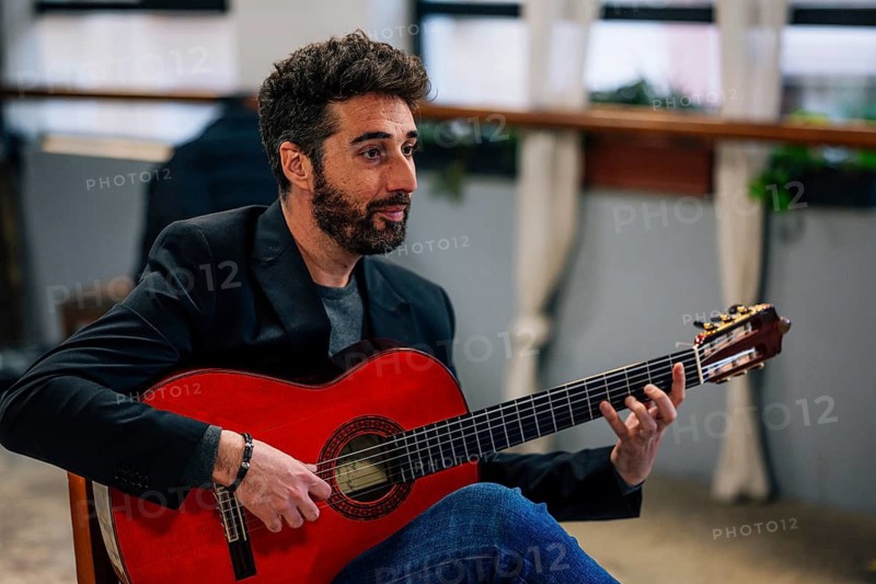 Side view of male playing guitar in music studio