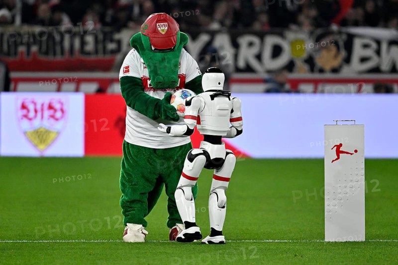 During the DFL and VfB Stuttgart Innovation Matchday, an AI-supported robot hands over the Adidas Derbystar game ball to the mascot Fritzle VfB Stuttgart logo soccer Bundesliga, MHPArena, MHP Arena Stuttgart, Baden-Württemberg, Germany