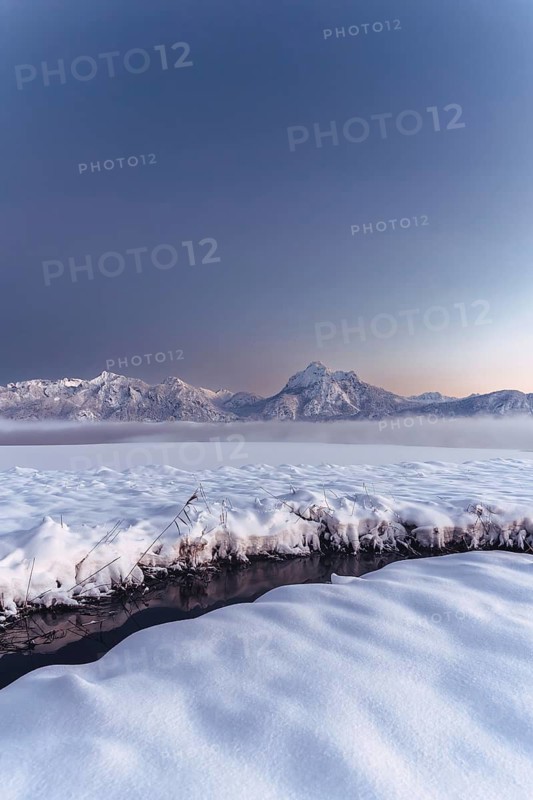 Shortly after sunset, twilight at Lake Hopfensee in the Allgäu in Bavaria in a winter landscape, Germany