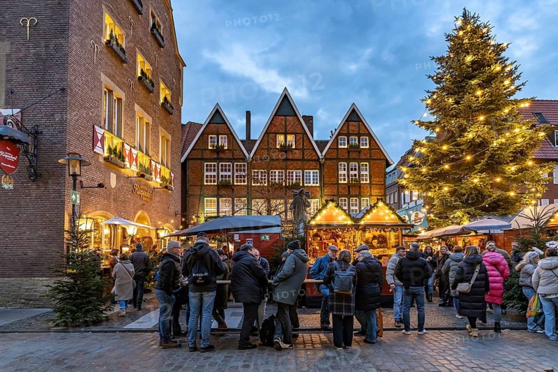 Christmas market or Christmas village at the Kiepenkerl memorial at dusk, Münster, North Rhine-Westphalia, Germany