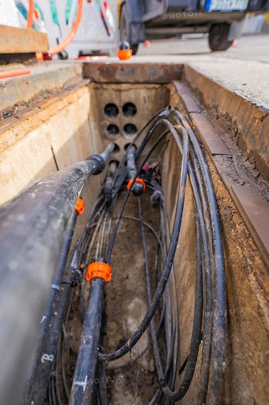 View into an open shaft with cables and pipes at a construction site, Wend Glasfasermontage during the installation of conduits for fibre optic cables, Meßkirch, district of Sigmaringen, Germany