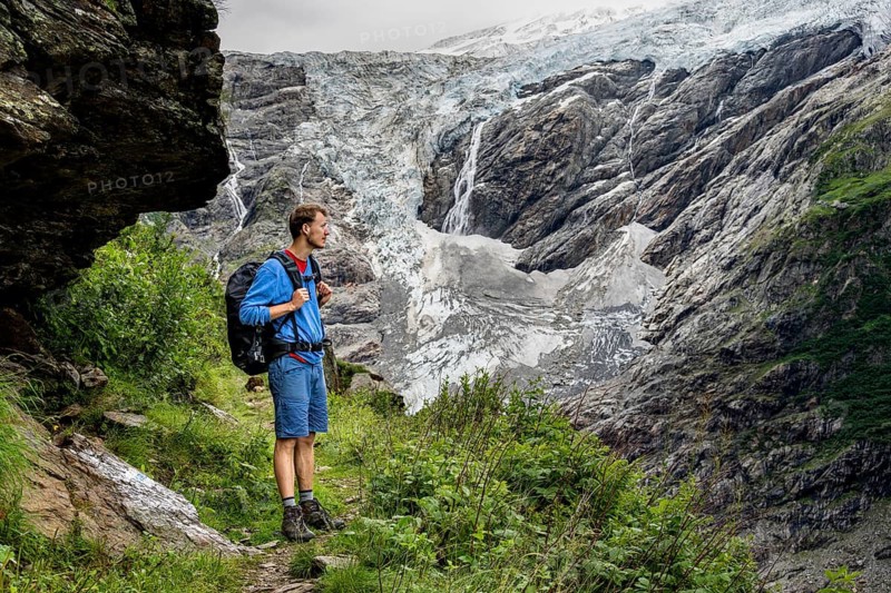 Mountaineers on a hiking trail in front of glaciers, cloudy mountain landscape with Grindelwald-Fiescherfirn glacier, Bernese Alps, Bernese Oberland, Switzerland