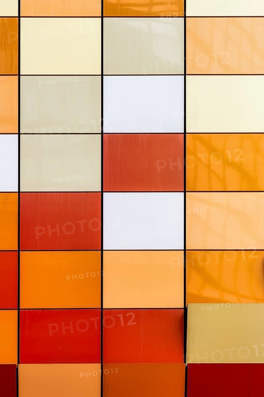Close-up view of a vibrant and multi-colored tiled facade of a building in Hong Kong. The image showcases a spectrum of colors arranged neatly in squares, offering a modern architectural aesthetic