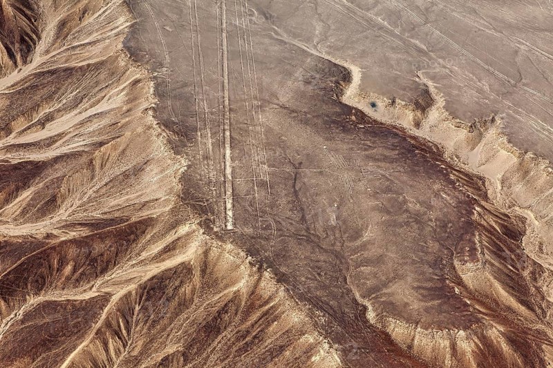 Aerial view of brown desert hills with subtle lines and patterns, rich in geological forms, the geoglyphs and images in the desert near Nasca and Palpa in Peru