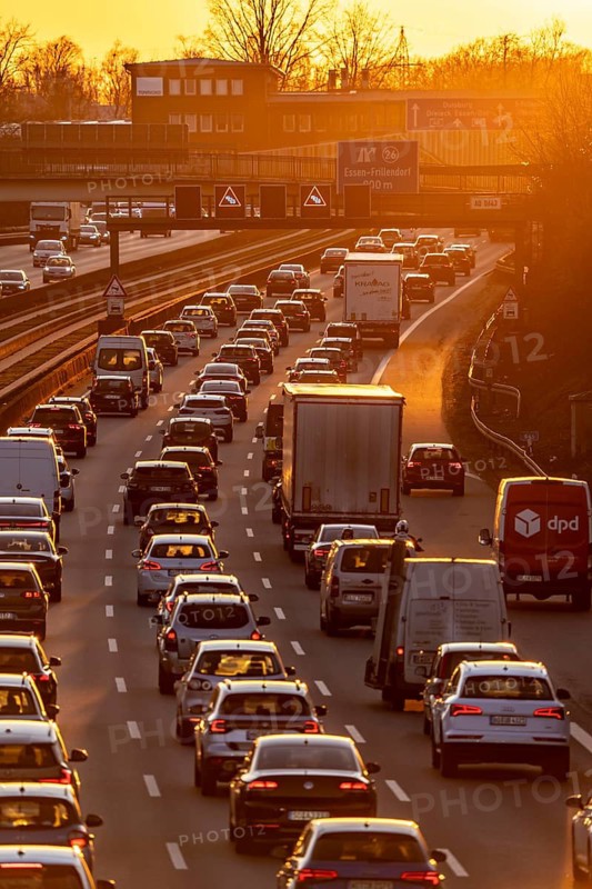 Motorway A40, dense, slow-moving traffic jam, evening traffic at the Essen-Kray junction, low sun, public transport bus lane in the middle of the motorway, North Rhine-Westphalia, Germany