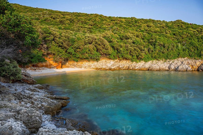Crystal clear and turquoise water on the beach of Ustrine Bay on a sunny day at sunset on the island of Cres, long exposure, Croatia