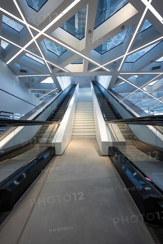 Modern escalator in a futuristic building with geometric ceiling and glass roof, Porsche Museum, Stuttgart, Germany