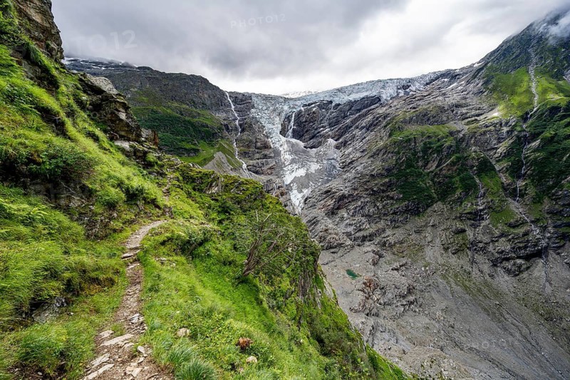 Hiking trail on a steep mountainside, cloud-covered mountain landscape with Grindelwald-Fiescherfirn glacier, Bernese Alps, Bernese Oberland, Switzerland