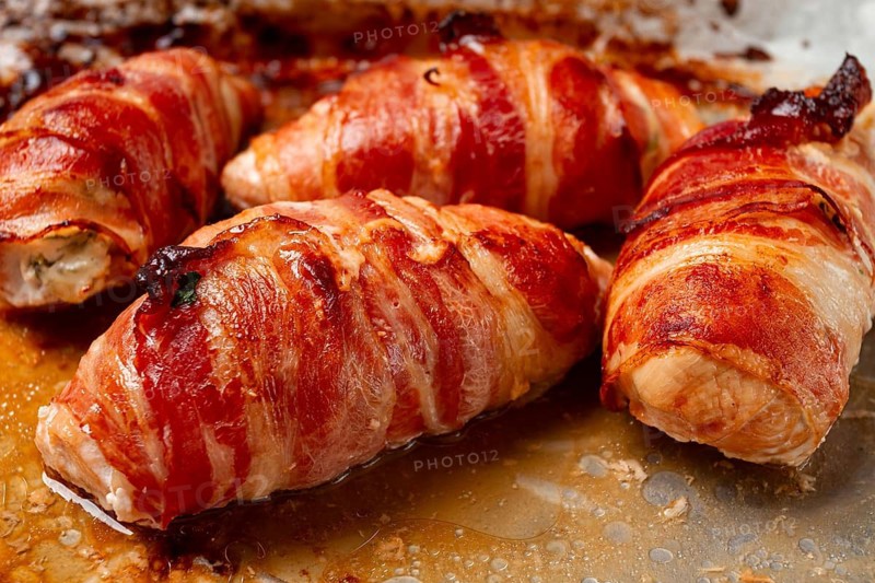 Baked chicken breast, wrapped in bacon, on a baking tray. in the home kitchen.close-up