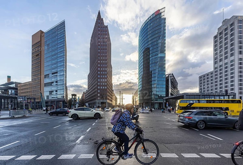Potsdamer Platz Berlin in the evening with traffic on the streets. BVG cyclists and double-decker bus. When it rains, the skyscrapers are reflected in puddles of water. Berlin, Germany