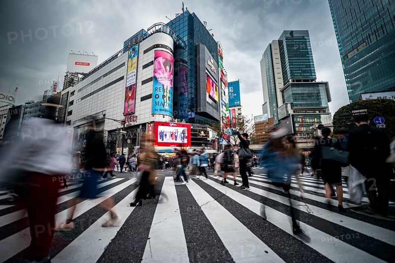 Crowd crossing zebra crossing on a large intersection, motion blur, back modern houses with colorful neon signs, long exposure, Shibuya Crossing, Shibuya, Tokyo, Japan
