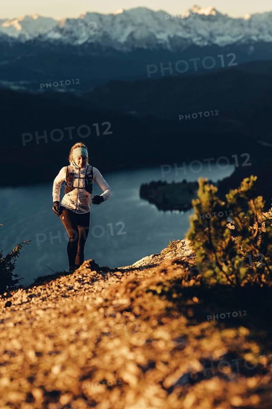 Trail running in autumn on the Jochberg on Lake Walchensee against the wonderful backdrop of the Alps, Bavaria, Germany