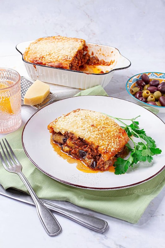 Moussaka served with olives, in a bright kitchen setting, homemade, no people