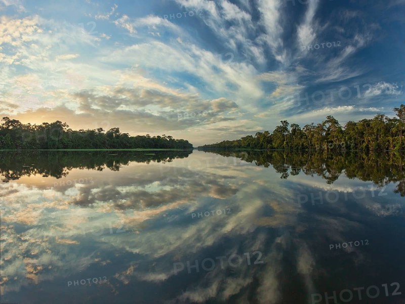 I worked hard for this shot. I wanted a wide view of the the open lagoons in Costa Rica's amazing Tortuguero National Park. Scouting by private boat, I found my spot one afternoon but it was a sunrise shot. A quick check of a GPS app on my phone confirmed that sunrise would be in the right direction for the composition I wanted. Nonetheless, I took the opportunity to take some test shots and frame the scene. The tricky part would be using a tripod. Since I would be shooting at sunrise, the light would be low, handholding would not be an option. But, I was shooting from a boat. How could I use a tripod for relatively long exposures? My first thought was to get into the water with my tripod. There are lots of large crocodiles in the area though so that seemed immediately like a bad idea :-) My second thought was that I would stay in the boat and lower my tripod into the water. I tried that but the currently was deceptively fast. Even if I weighted down my tripod it wasn't going to stay l...