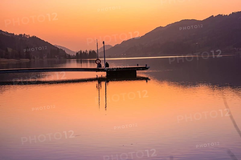 Footbridge juts into the lake, orange sky at sunset, quiet atmosphere, Großer Alpsee, Immenstadt im Allgäu, Bavaria, Germany