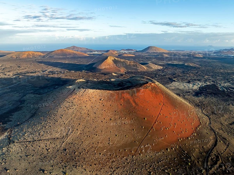 Caldera Colorada volcano, picturesque volcanic landscape with volcanic craters and lava fields in morning light, Parque Natural de Los Volcanes, aerial view, Lanzarote, Canary Islands, Spain