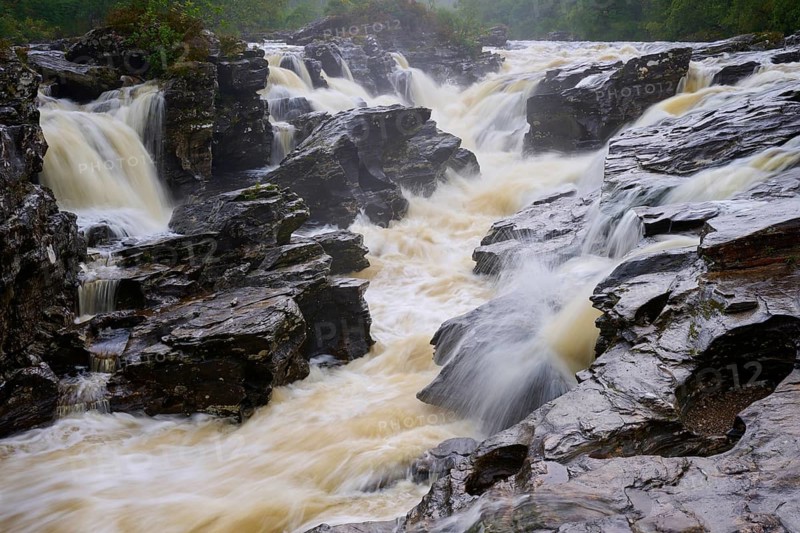 A wild, torrential waterfall flowing over dark rocks in a natural setting, River Orchy, Eas Urchaidh, Bridge of Orchy, Scotland, United Kingdom, United Kingdom