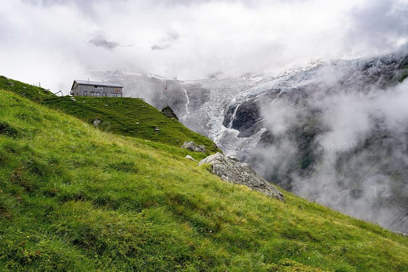 Berghaus Bäregg mountain hut, cloudy mountain landscape with Grindelwald-Fiescherfirn glacier, Bernese Alps, Bernese Oberland, Switzerland