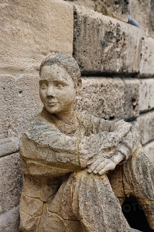 Sculpture in front of the old school building, art in public space, stone figure, sculpture by the artist Ulla Frenger, depiction of a pupil, building from 1867 made of Gönningen tuff, former elementary and secondary school, today the Gönningen branch of the town library, Gönningen, Reutlingen district, Baden-Württemberg, Germany