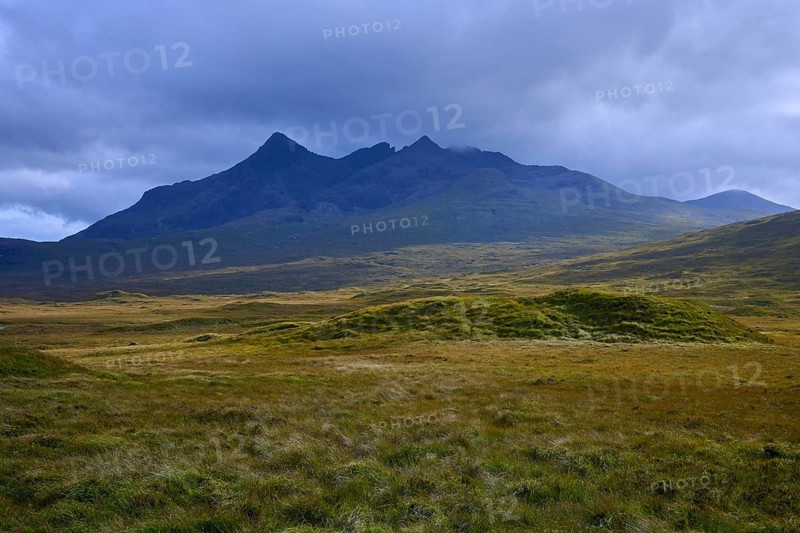 Rolling meadows in front of a massive mountain under dark clouds, Sligachan, Isle of Skye, Scotland, United Kingdom, United Kingdom