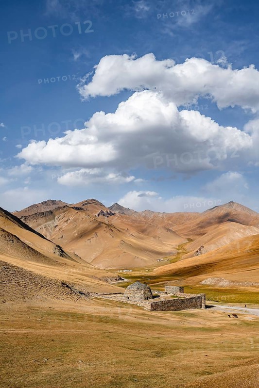 Historic caravanserai Tash Rabat from the 15th century, with yellow hills, Atbashy district in the Naryn region, Kyrgyzstan