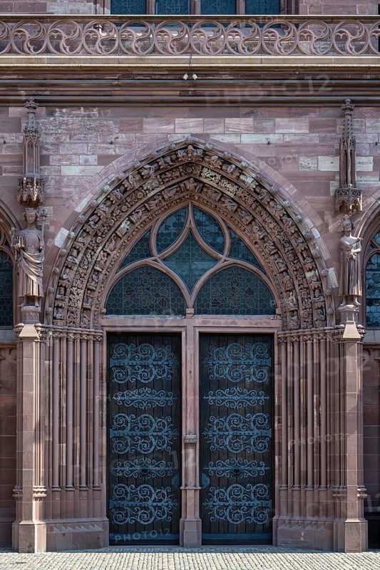 The main portal of Basel Cathedral with iron-clad wooden doors and richly decorated red sandstone sculpture decoration, Old Town, Basel, Canton of Basel-Stadt, Switzerland