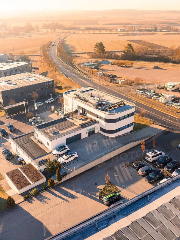 Modern style building in industrial area with surrounding streets and fields in sunny weather, Gültstein, Herrenberg, Germany