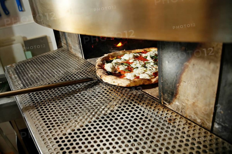 A freshly baked pizza out of an industrial oven, perfectly cooked with vibrant toppings