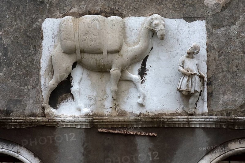 Historical relief with Moorish merchant and camel on the façade of a palazzo, Venice, Veneto, Italy