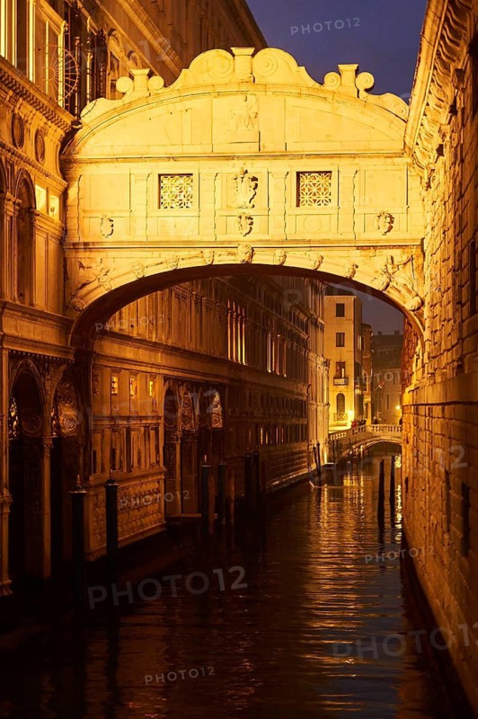 View from 'Ponte della paglia' on the bridge 'Bridge of Sighs' over a waterway at the blue hour in the evening in Venice, Italy