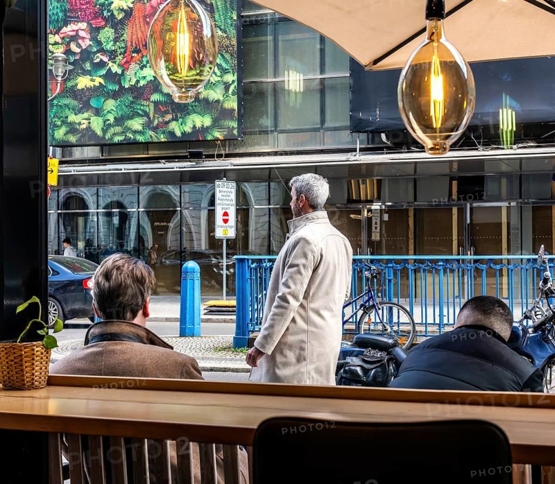 View through the window of a café of passers-by on Friedrichstraße in Mitte, Berlin, Germany