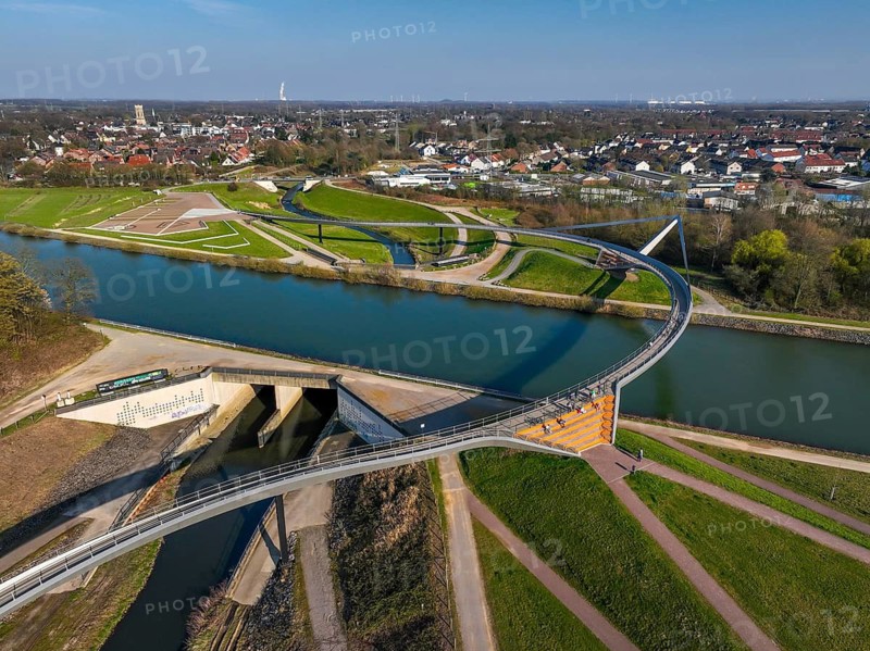 Castrop-Rauxel, North Rhine-Westphalia, Ruhr region, Germany - Sprung bridge over the Emscher, a footbridge and cycle path across the Emscher and the Rhine-Herne Canal. EMSCHERLAND adventure park, new nature and water adventure park on the restored Emscher, at the Emscher water cross with the Rhine-Herne Canal on the city limits of Recklinghausen and Castrop-Rauxel. Flood protection through area expansion. The ecological focus at the confluence of the Suderwicher Bach and Emscher rivers will also be a future garden of the IGA 2027 International Garden Exhibition. Before the restoration, the river system of the Emscher was an open, aboveground waste water channel, mixed water channel with surface water and waste water