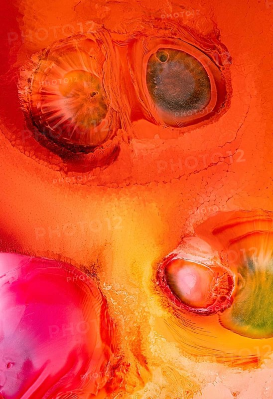 This vibrant abstract image features liquids shapes and vivid colors. With a mix of orange, pink, and green hues, it evokes a sense of motion and galactic beauty
