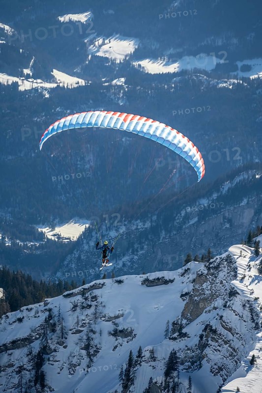 Mountains in winter, paraglider with skis on Sonntagshorn, Chiemgau Alps, Bavaria, Germany