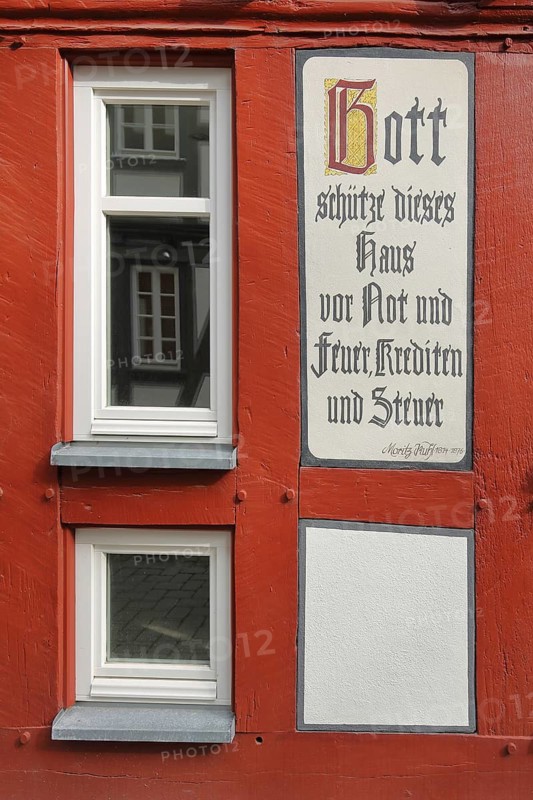 Quote by Moritz Kuhl: God save this house from misery and fire, loans and taxes, text, saying, inscription, saying, rhyme, tax, credit, loan, finance, banking, guard, guard, protect, preserve, preserve, misery, protection, half-timbered house with window, Butzbacher Zeitung Presse, Langgasse, Butzbach, Wetterau, Hesse, Germany