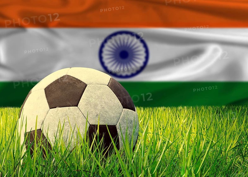 Soccer ball on the grass with India flag in the background. Soccer ball on pitch against Indian flag in the background