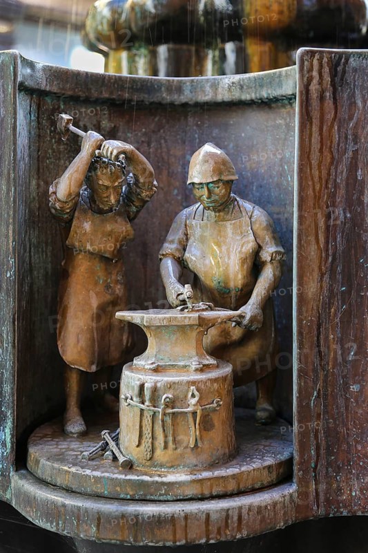 Guild fountain by the sculptor Bonifatius Stirnberg from 1983, guilds, guilds, craftsmen, cast figure, blacksmith, anvil, two men, Reutlingen, Baden-Württemberg, Germany