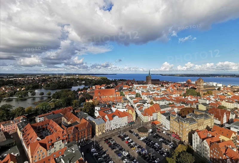 Historic city with red roofs on the riverbank under blue, cloudy sky, view over Szczecin, Poland