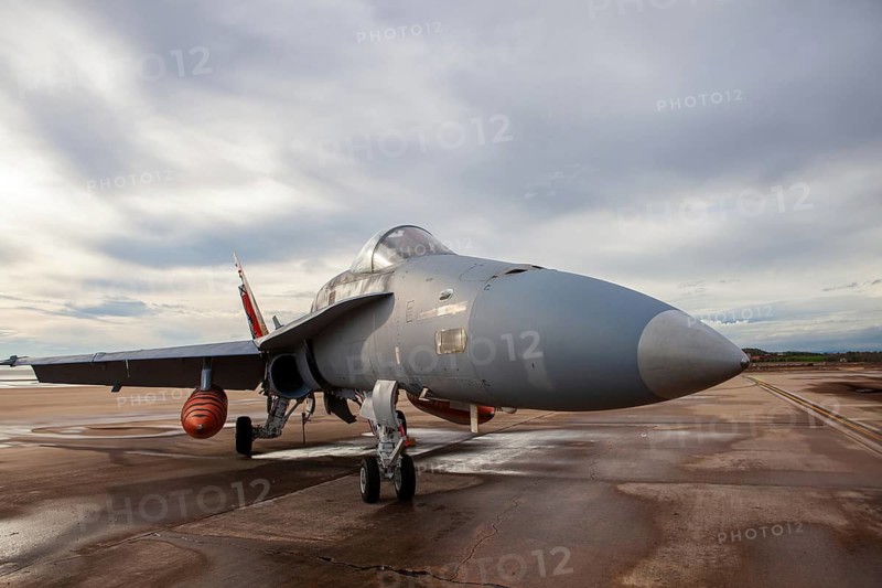 A fighter jet showcased on the tarmac of Torrejon Air Base, Spain. The aircraft is ready for an aerial exhibition, with a cloudy sky in the background
