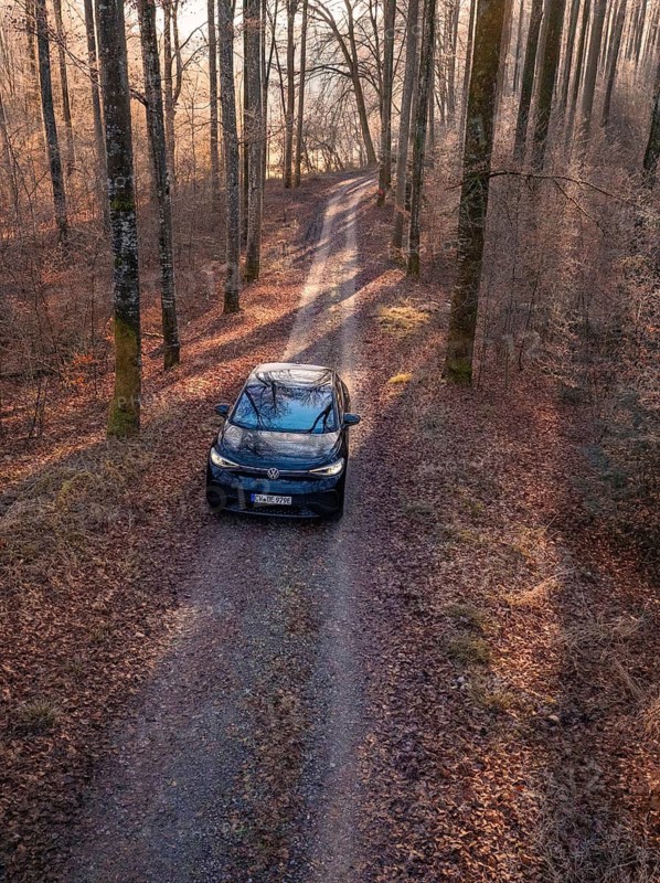 Aerial view of a car on a forest path, surrounded by tall trees in autumn, car sharing, electric car, Volkswagen ID 5, Gechingen, Hecken und Gäu region, Black Forest, Germany