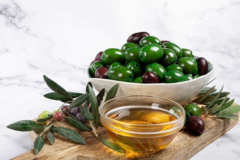 Chalkidiki olives, classic Greek green olives, in a bowl on a cutting board, top view, without people