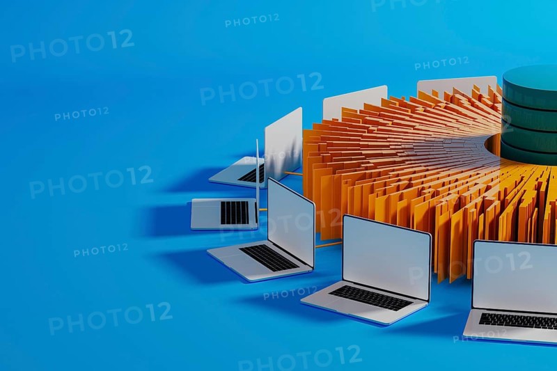 Multiple laptops surround a central data hub, showcasing technology integration for artificial intelligence advancements in a modern workspace