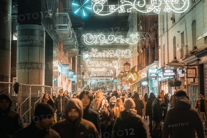 People strolling around town under Christmas lights, New Year's Eve London, Great Britain