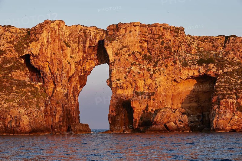 Dramatic rock formation with arches in the sea at early morning time, morning light, Tsichli Babas islet, Navarino Bay, Pylos, Peloponnese, Greece