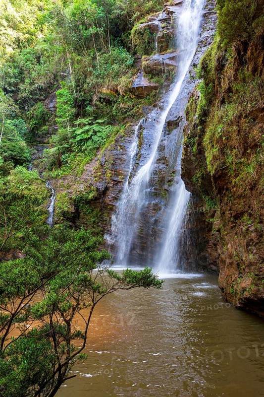 Beautiful waterfall among the dense vegetation of rainfoest and rocks in the state of Minas Gerais, Brazil